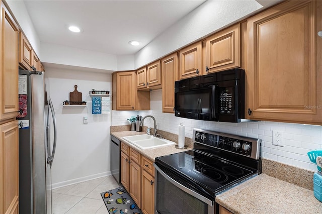 kitchen with appliances with stainless steel finishes, light stone counters, decorative backsplash, light tile patterned flooring, and sink