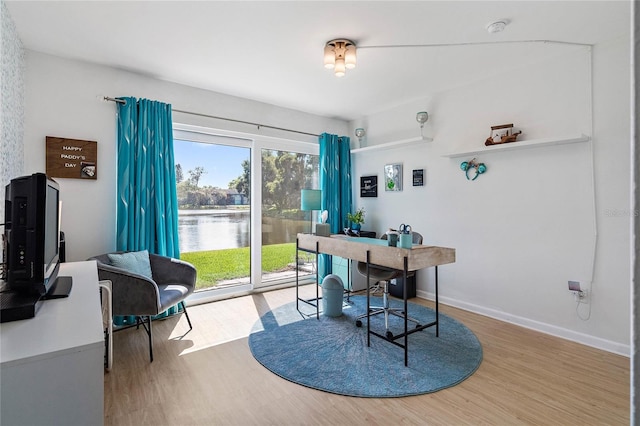 office featuring hardwood / wood-style floors and a water view