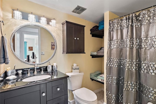 bathroom with toilet, vanity, and walk in shower