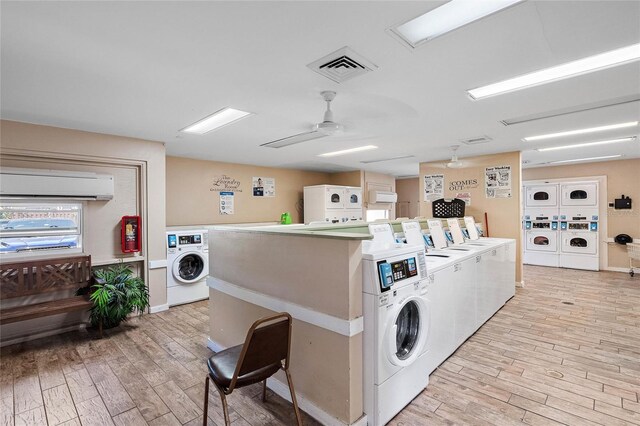 laundry room featuring ceiling fan, stacked washer / dryer, light hardwood / wood-style flooring, and washing machine and clothes dryer