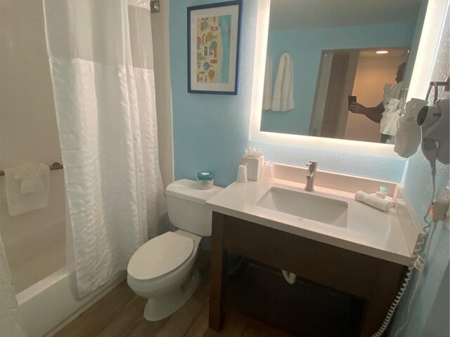 full bathroom with vanity, toilet, shower / tub combo with curtain, and wood-type flooring