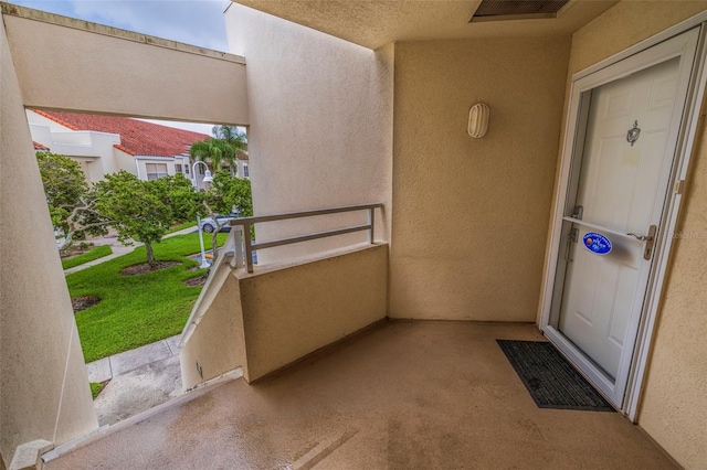 doorway to property featuring a balcony and a yard