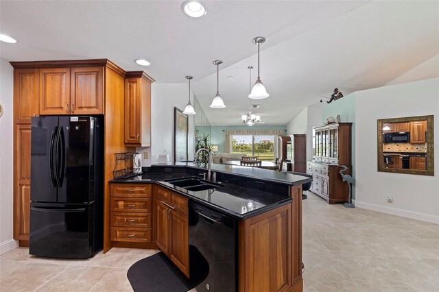 kitchen with pendant lighting, brown cabinets, a sink, dark stone countertops, and black appliances