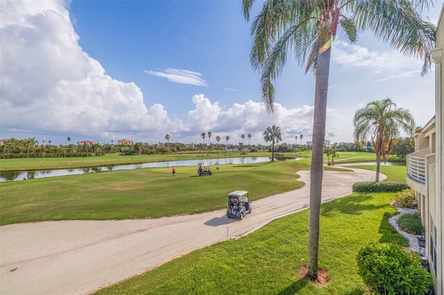 surrounding community with a water view and a lawn