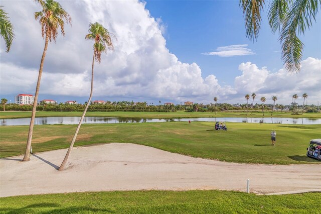 surrounding community featuring a water view and a lawn