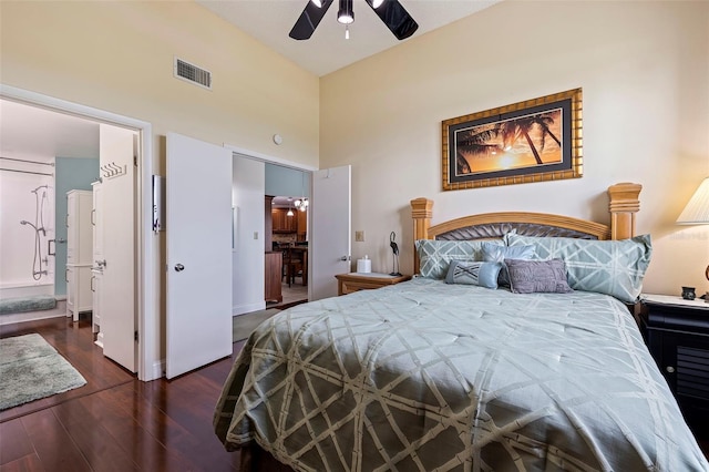 bedroom with ceiling fan, dark hardwood / wood-style flooring, and a towering ceiling