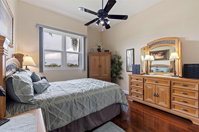bedroom featuring a ceiling fan, dark wood-style flooring, and baseboards