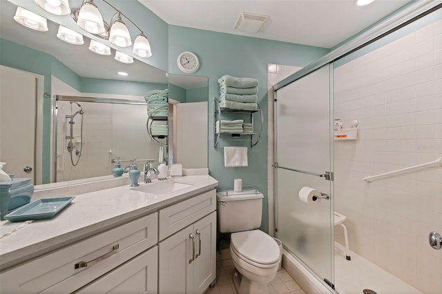 bathroom featuring walk in shower, vanity, tile patterned flooring, and toilet