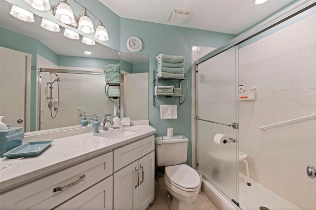 bathroom featuring vanity, tile patterned flooring, a shower stall, and toilet