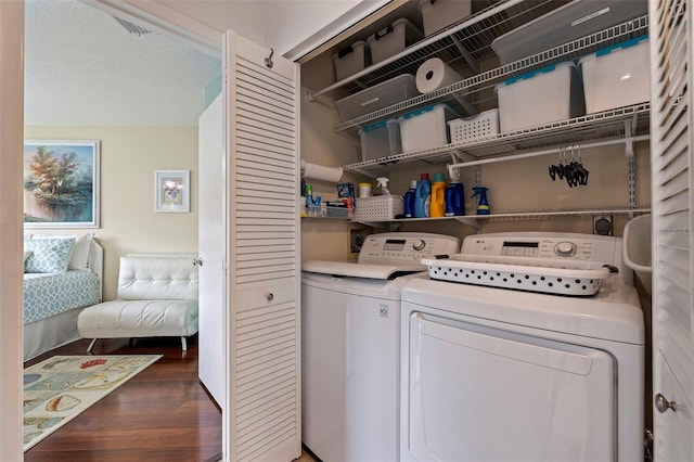 laundry area with dark hardwood / wood-style floors, a textured ceiling, and washer and clothes dryer