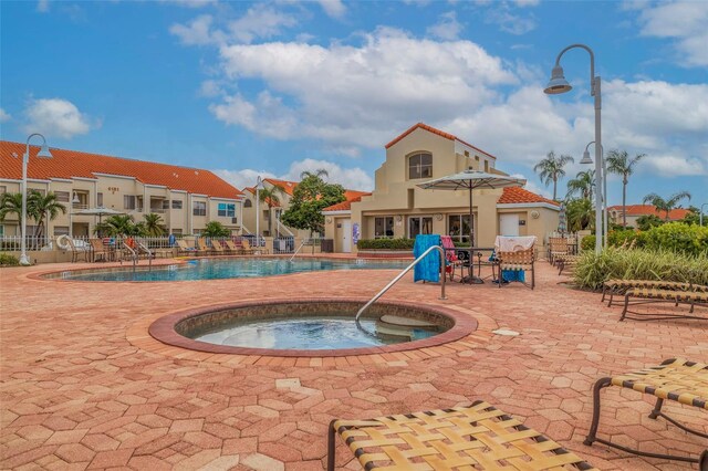 pool featuring a residential view and a hot tub