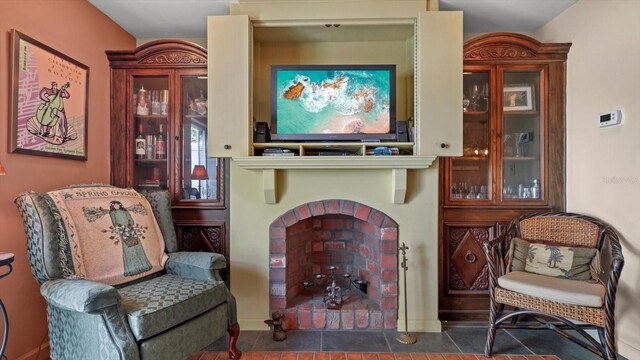 sitting room with a fireplace and dark tile patterned floors