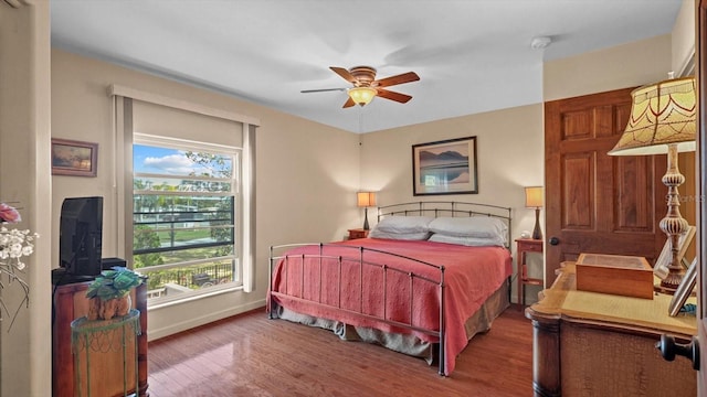 bedroom with ceiling fan, baseboards, and wood finished floors