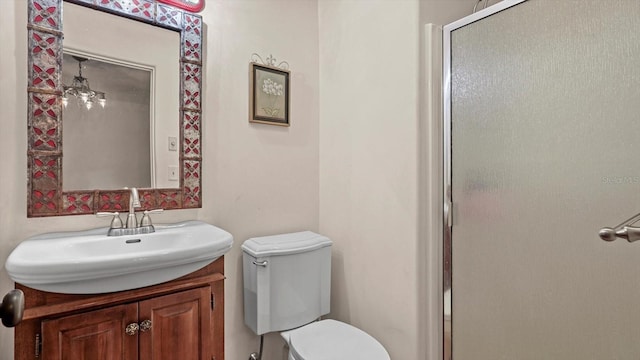 bathroom with an enclosed shower, vanity, and toilet