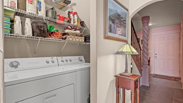 laundry area featuring dark tile patterned flooring and washing machine and clothes dryer