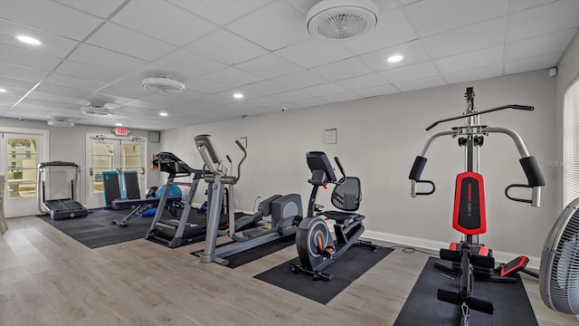 gym featuring light hardwood / wood-style floors and a drop ceiling