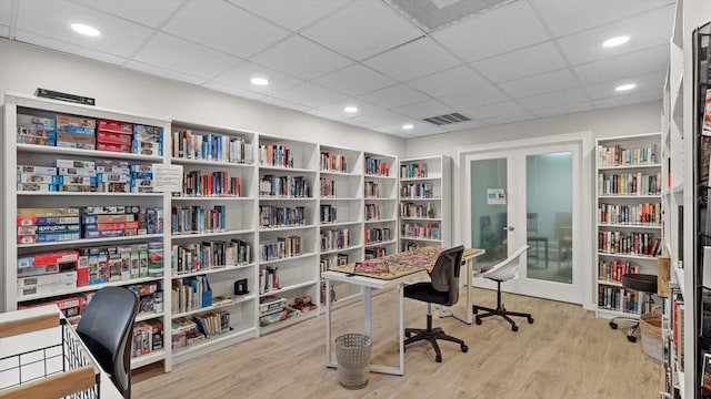 office space with a paneled ceiling and light hardwood / wood-style flooring