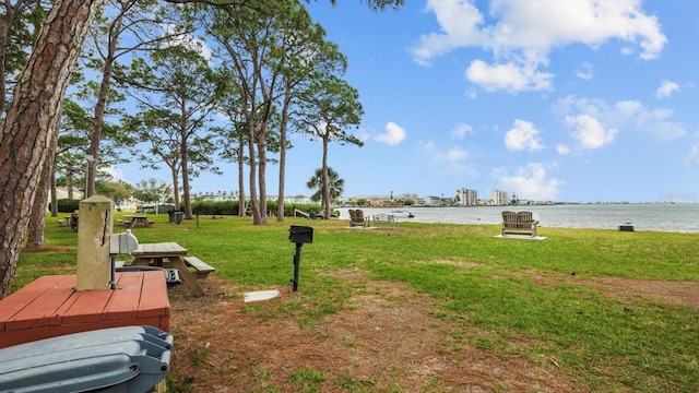 view of property's community with a water view and a lawn