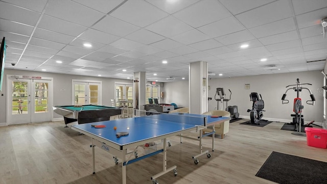 rec room with a paneled ceiling, recessed lighting, baseboards, french doors, and light wood finished floors