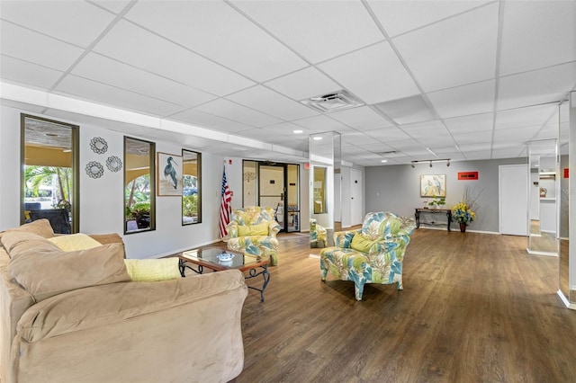 living area with a paneled ceiling, visible vents, and wood finished floors