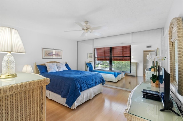 bedroom with visible vents, ceiling fan, a textured ceiling, and wood finished floors