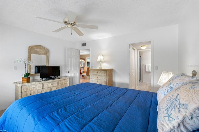 bedroom with visible vents, a ceiling fan, a textured ceiling, and light tile patterned flooring