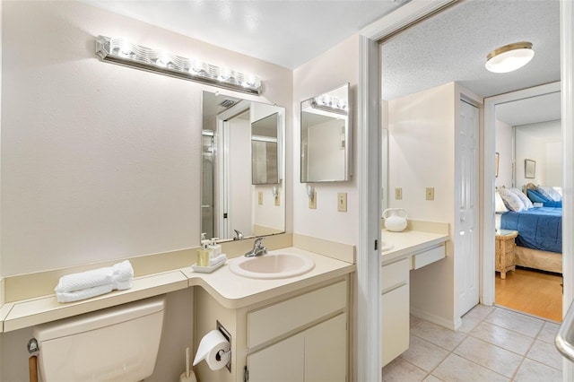 bathroom featuring ensuite bathroom, toilet, tile patterned flooring, and vanity