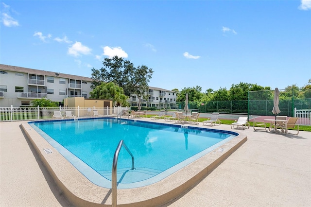 pool with fence and a patio