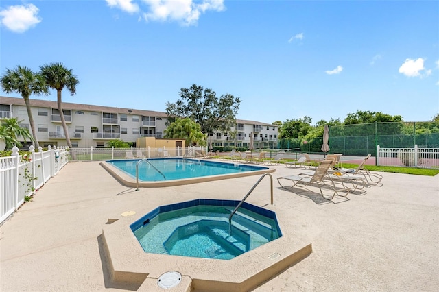 community pool featuring a community hot tub, a patio, and fence