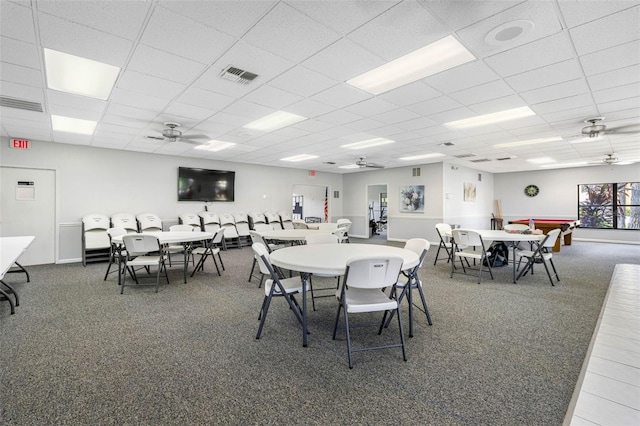 carpeted dining space with ceiling fan, visible vents, and a drop ceiling