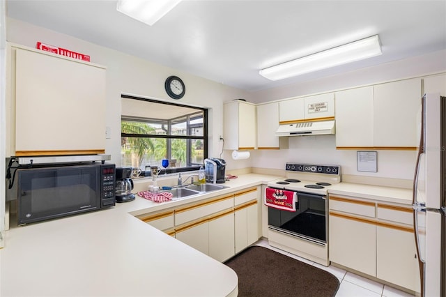 kitchen with black microwave, light countertops, electric stove, and freestanding refrigerator