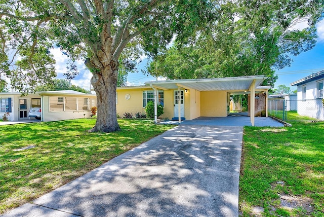 10162 115th Ave, Largo, FL 33773 - ranch-style home with driveway, fence, a front lawn, and stucco siding