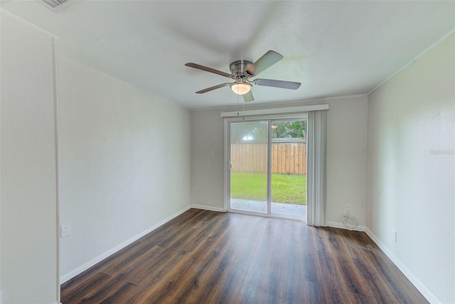 spare room featuring a ceiling fan, dark wood finished floors, and baseboards