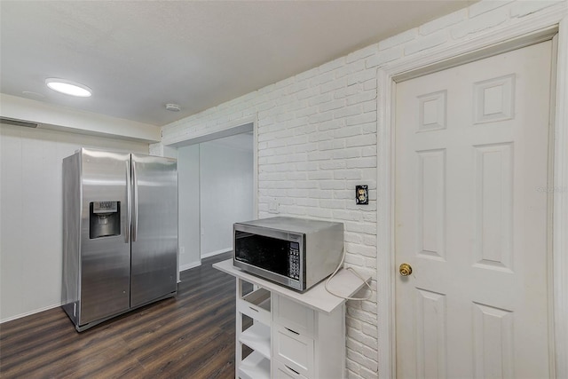 kitchen with brick wall, stainless steel appliances, dark wood finished floors, and visible vents