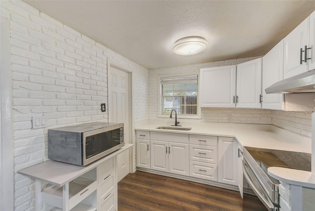 kitchen featuring stainless steel appliances, light countertops, white cabinets, and a sink