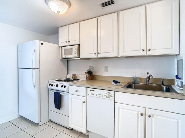 kitchen featuring sink, white cabinetry, white appliances, and light tile patterned flooring