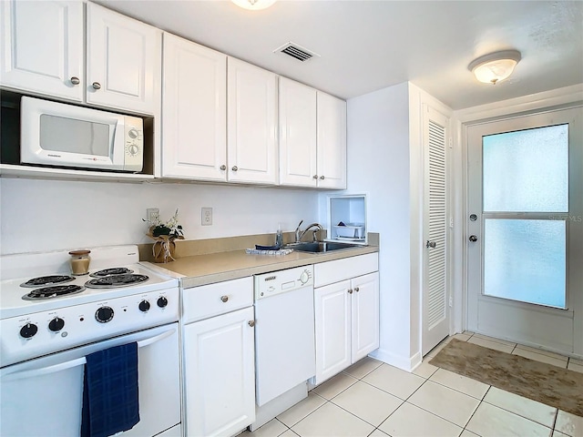 kitchen featuring white appliances, white cabinets, sink, and light tile patterned floors