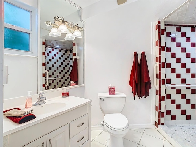 bathroom with vanity, toilet, a tile shower, and tile patterned flooring