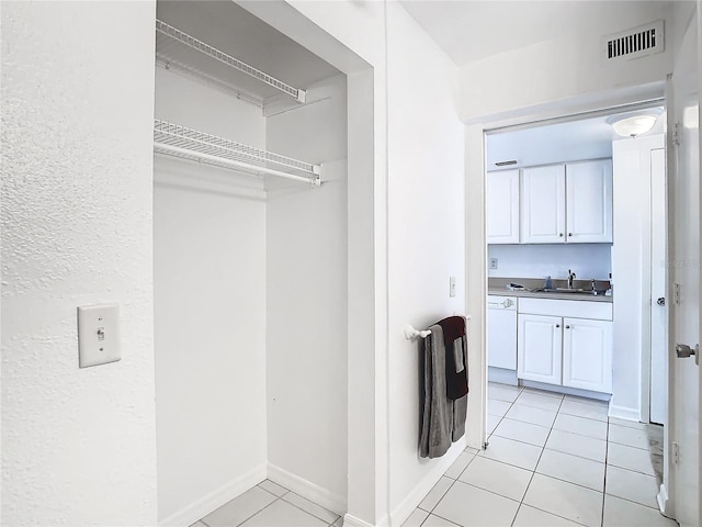 laundry area with sink and light tile patterned floors