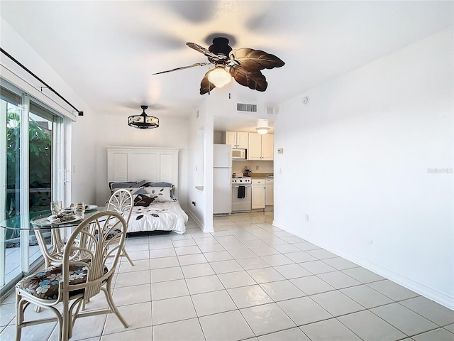 bedroom with ceiling fan, light tile patterned floors, and white refrigerator