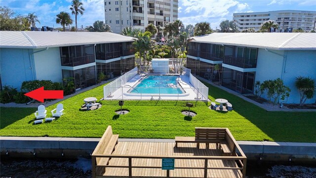 view of swimming pool with a sunroom and a yard