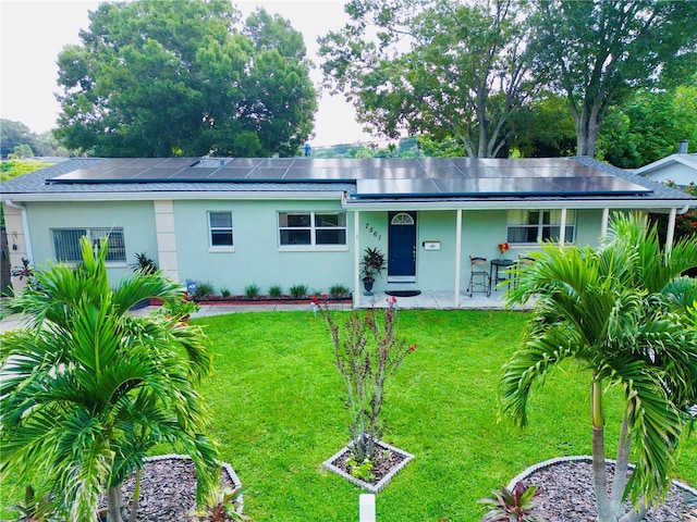 ranch-style home with stucco siding, solar panels, and a front lawn