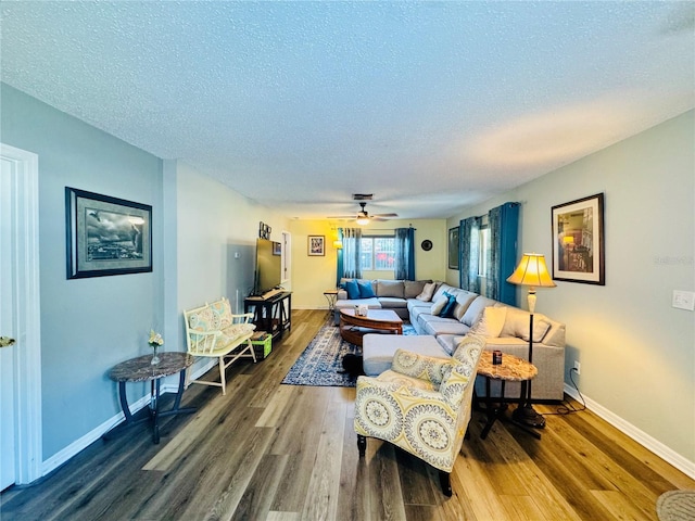 living room featuring hardwood / wood-style flooring, a textured ceiling, and ceiling fan