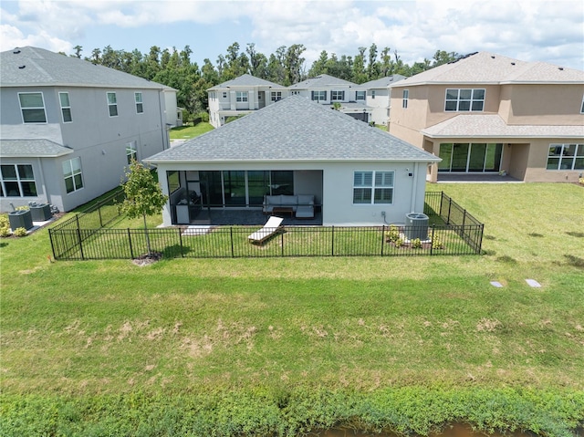 rear view of house with central air condition unit, a sunroom, and a yard