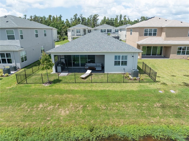 rear view of house featuring central air condition unit, a lawn, and a sunroom