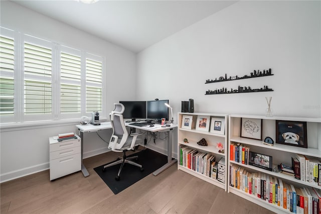 home office with lofted ceiling and light wood-type flooring