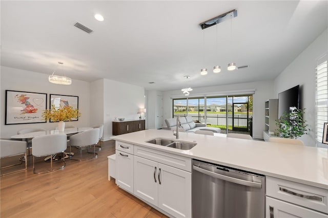 kitchen with pendant lighting, dishwasher, light wood-type flooring, sink, and white cabinetry