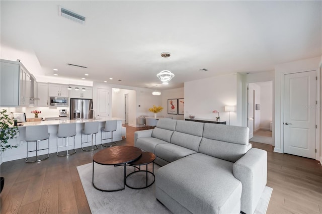 living room featuring light wood-type flooring and sink