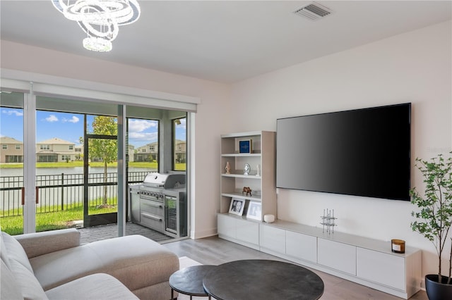 living room featuring light hardwood / wood-style flooring and a notable chandelier