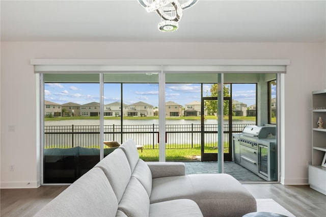 sunroom with a notable chandelier, a water view, and a healthy amount of sunlight